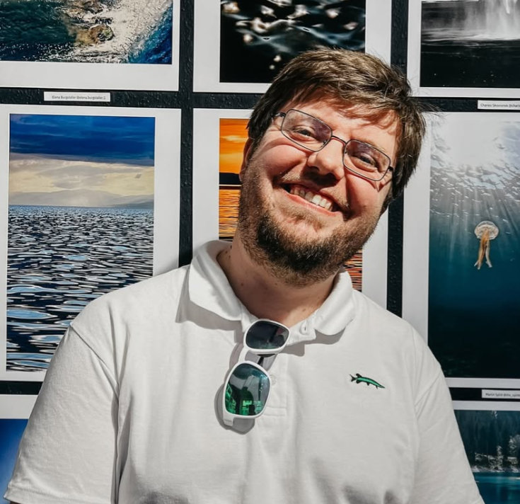 Martin Splitt, underwater photographer, in front of one of his photographs in an exhibition in Zurich